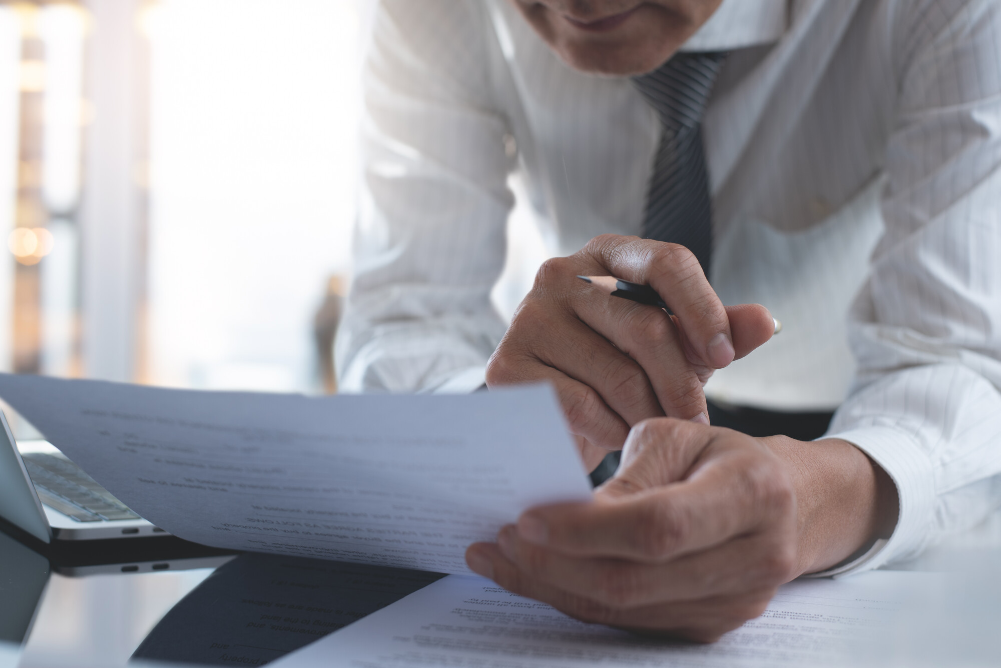 businessman reading carefully terms, conditions of business contract at office, close-up