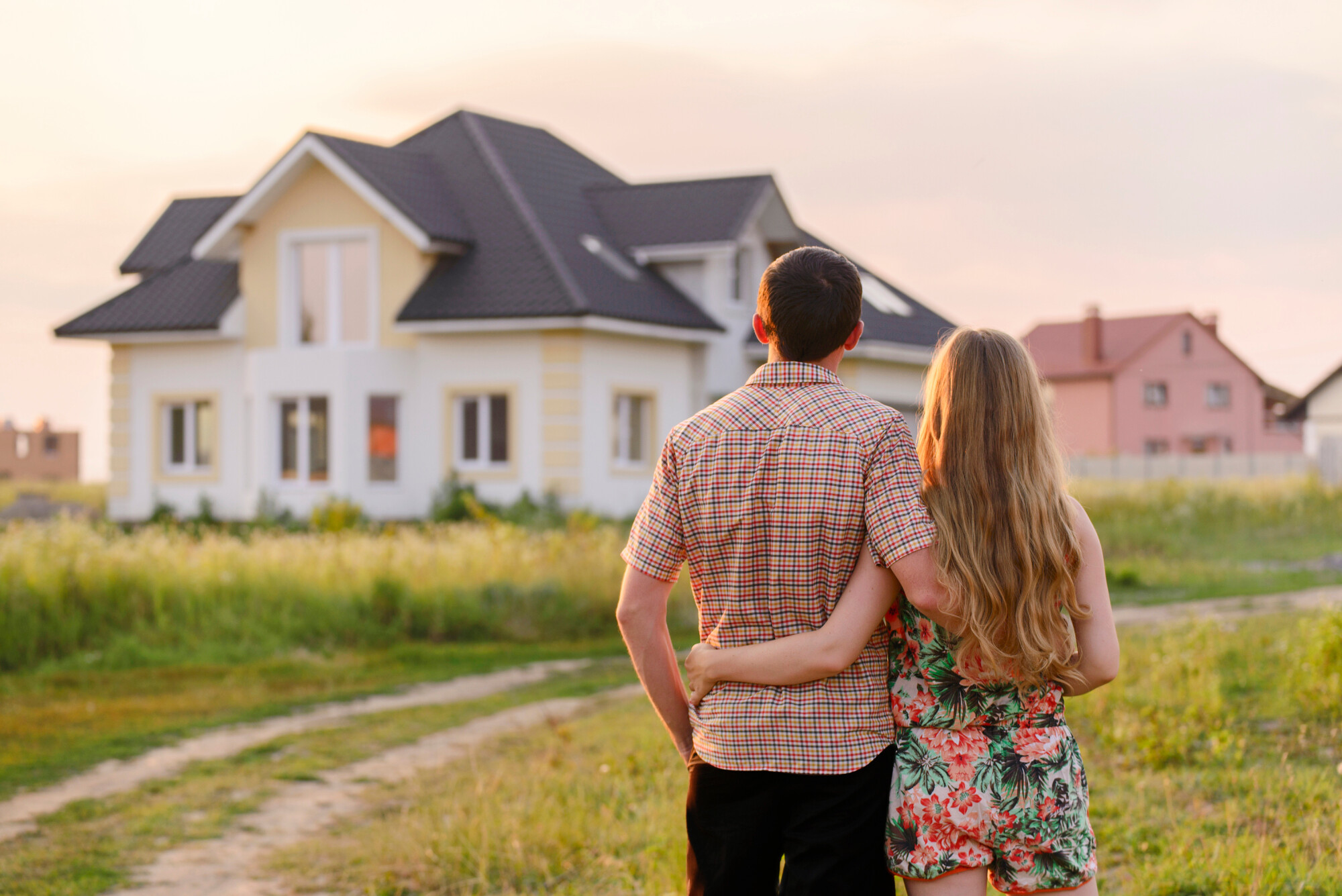 Rear view of young couple looking at their new house