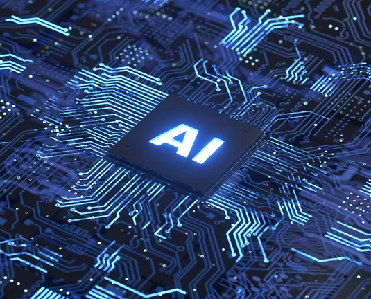 Close-up of a glowing computer chip labeled “AI” on a dark blue circuit board, symbolizing artificial intelligence technology and digital processing.