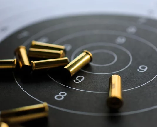 A pile of bullets sitting on a paper target.