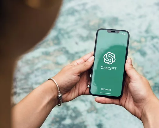 Someone holding a photo with the ChatGPT app up.