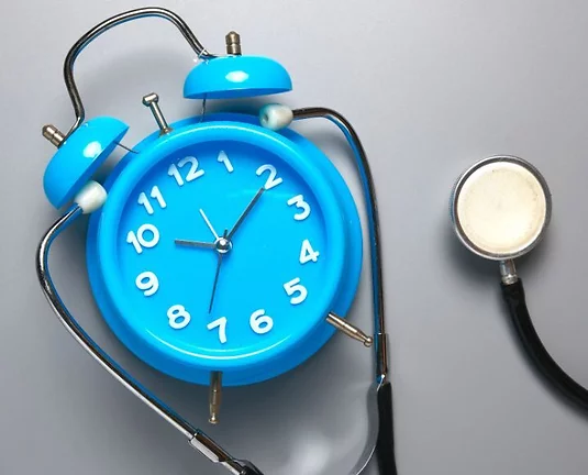 Picture of a blue clock wearing a stethoscope.