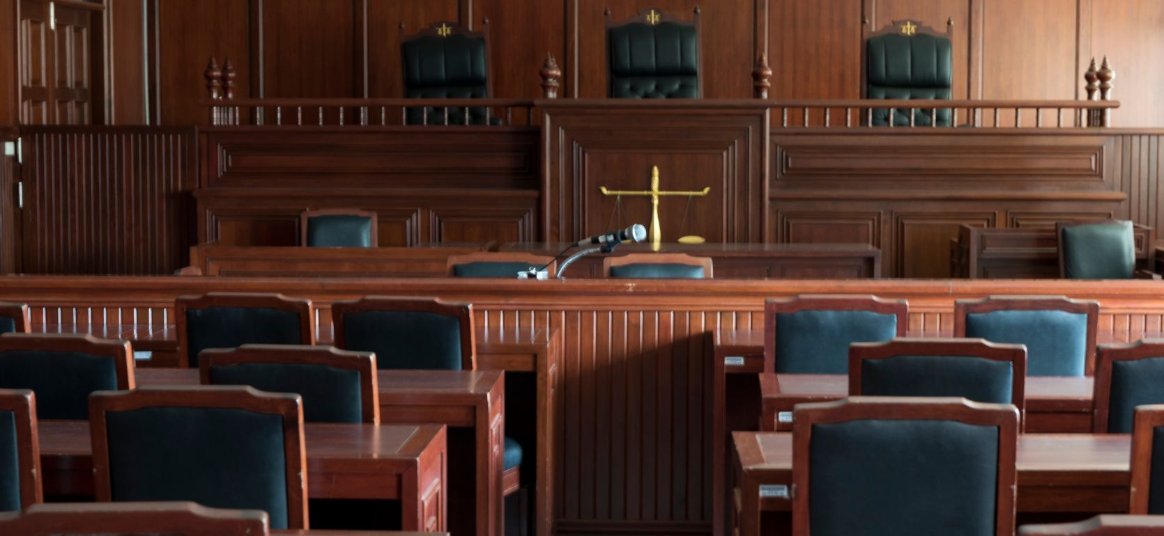 A court room with rows of chairs and a judges stand.