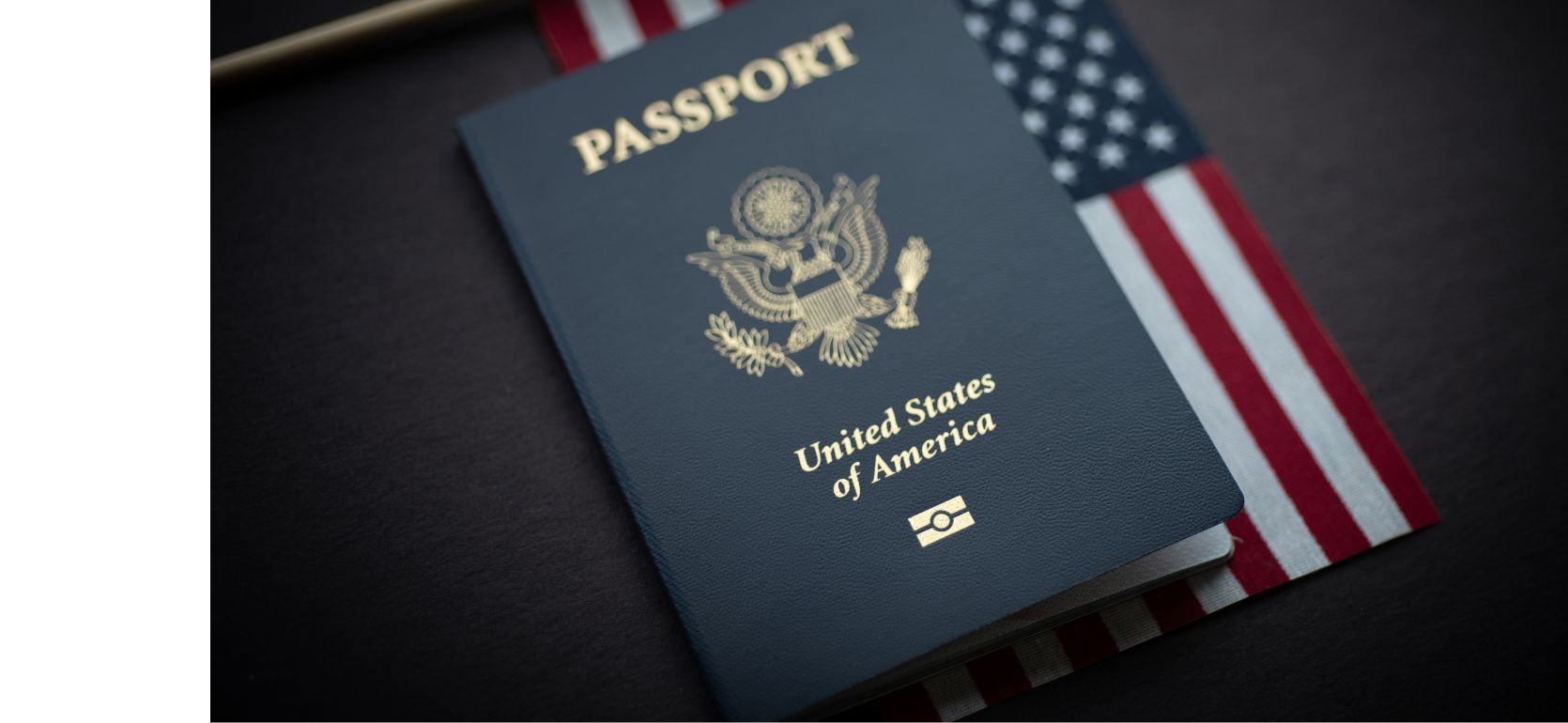 American passport sitting on top of a small American flag.