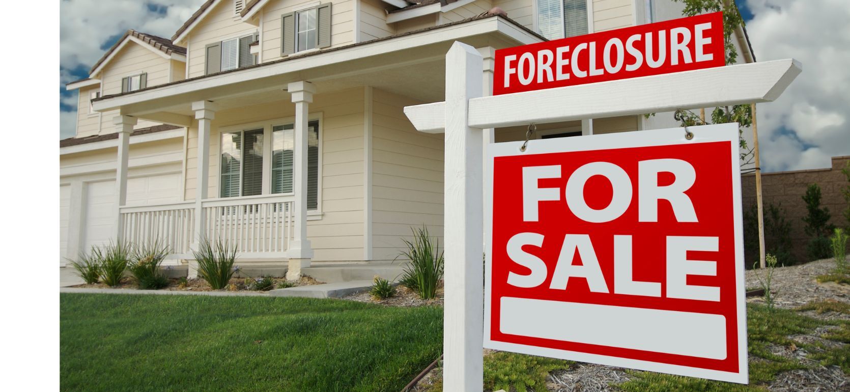 A foreclosure sign in front of a big white house.