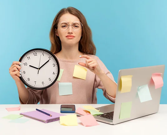Exhausted fatigued upset woman employee sitting at workplace office, all covered with sticky notes, holding big clock and showing a little bit gesture, begging more time.