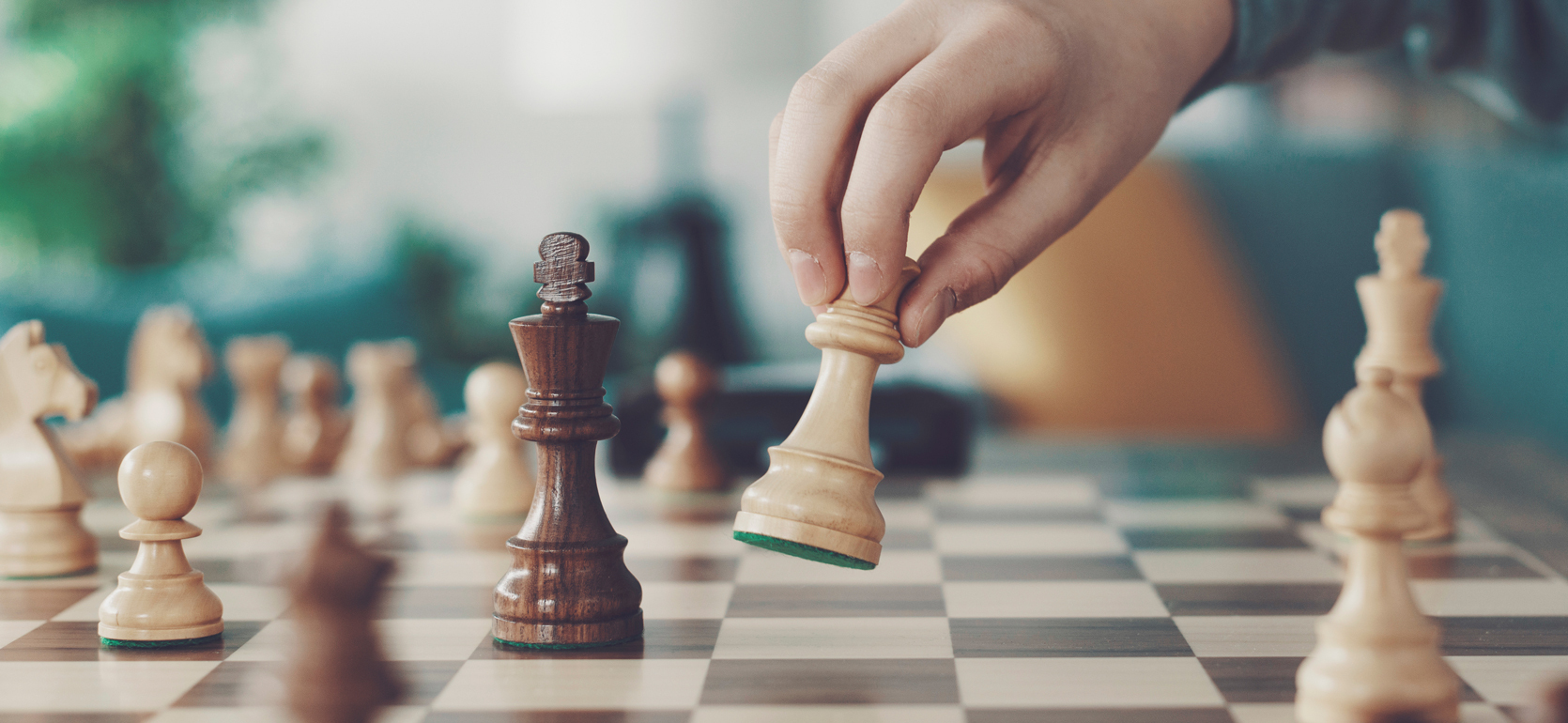 Single hand moving chess piece on chess board