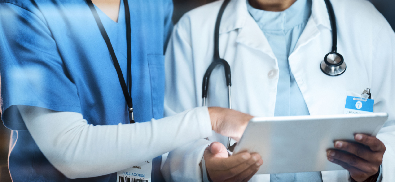 Nurse and Doctor Looking at tablet and pointing