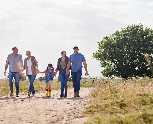 Love, happy family walking holding hands and on a farm with blue sky