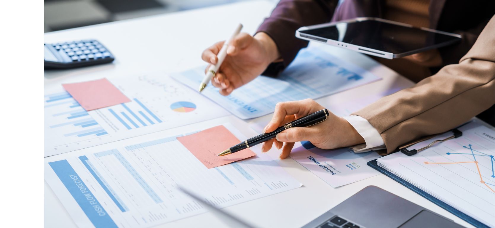 Two people looking over a table littered with papers.