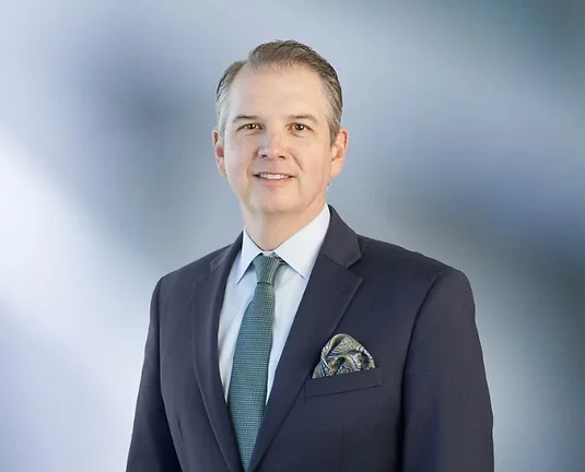 A picture of Matt Fedor wearing a suit, smiling.