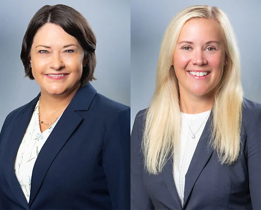 Two women attorneys, Marcy Hahn on left and Lisa Serra on right, smile at camera