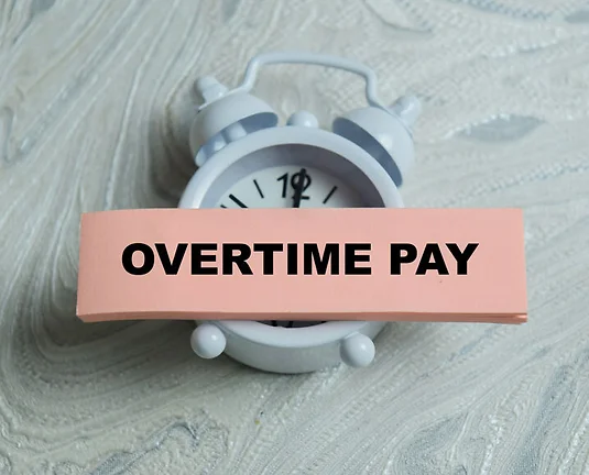 Concept of overtime pay write on sticky notes isolated on Wooden Table. For labor law and payroll