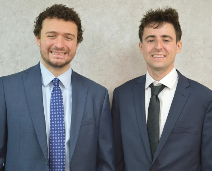 Picture of Zach Miller and Troy Brinkel wearing suits and smiling at the camera.