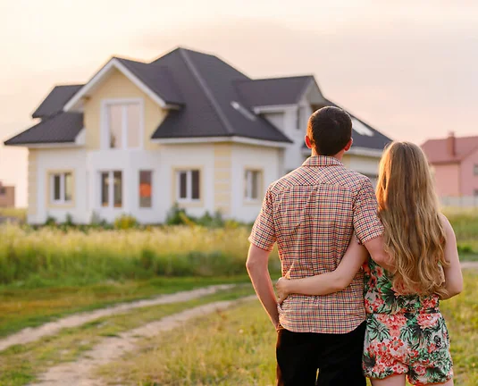 Rear view of young couple looking at their new house