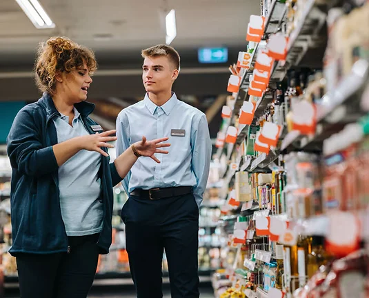 Supermarket manager giving training to a trainee