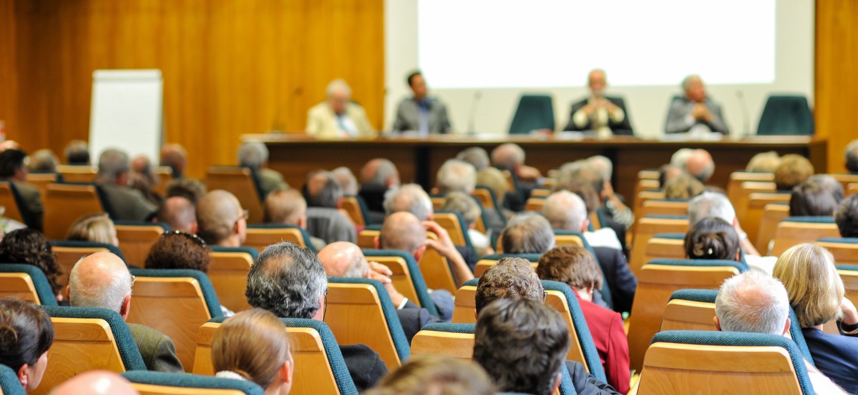 Picture of people sitting in a public meeting.