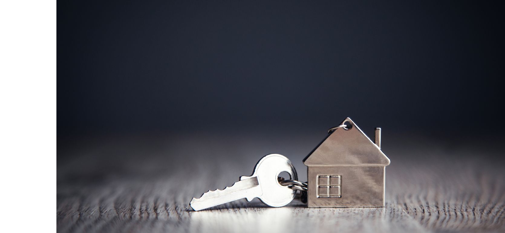 A key with a house shaped silver charm.