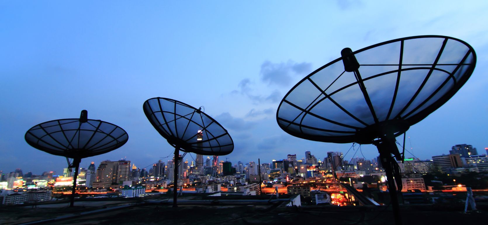 Phone satellites point at the sunset sky.