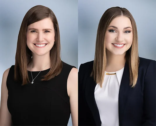 Amanda and Lindsey - Two Attorneys Smiling at Camera in front of blurred blue gray background