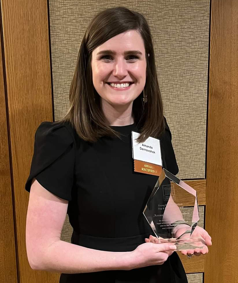Amanda Dervnovshek holding an award.